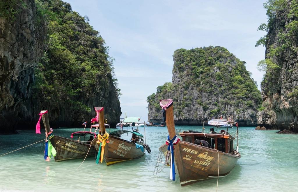 Longtail boats moored in a turquoise lagoon
